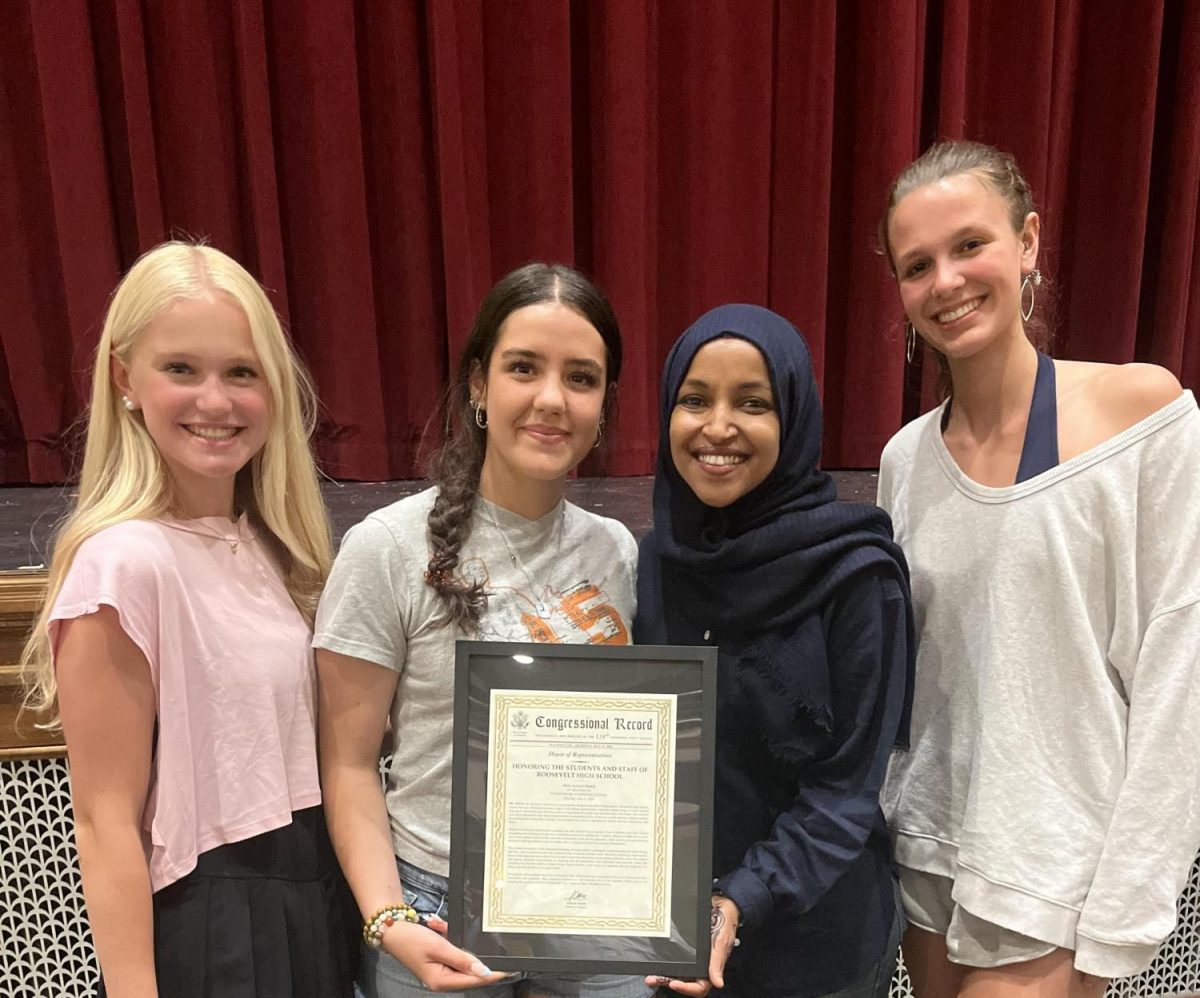 Editors Signe, Lila, and Thora pose with Ilhan Omar and framed congressional record